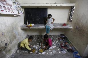 Children eat their free meal at a school run by Joint Women’s Programme, a non-governmental organization (NGO), at a slum area in Noida on the outskirts of New Delhi, July 14, 2015. REUTERS/Adnan Abidi